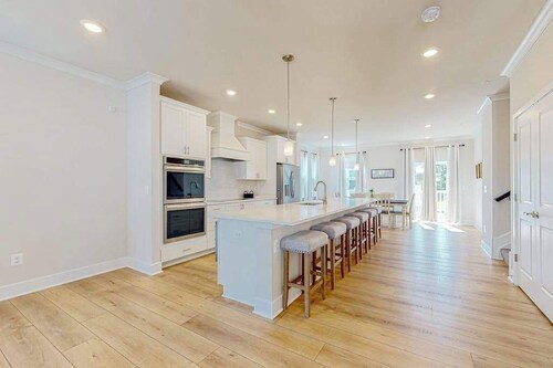 Newly built row-end townhome with water view, pool access, patio, & balcony