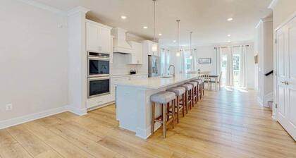 Newly built row-end townhome with water view, pool access, patio, & balcony