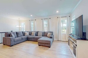 A modern living room with a sectional sofa, a TV, and a fireplace. - Sea Oaks Village 12434 #1 (Berlin)