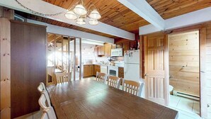 A wooden interior with a dining table, chairs, and a kitchen area. - Beach Place N 3 (Ocean City)