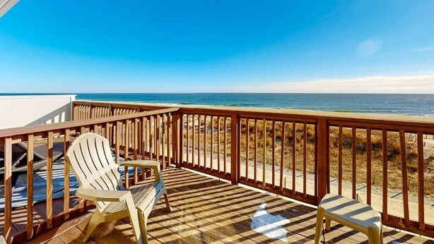 A wooden deck with a view of the ocean, two Adirondack chairs, and a railing. - Beach Place N 3 (Ocean City)