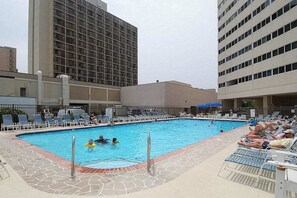 A swimming pool with lounge chairs and a building in the background. - Recently Updated Condo in Oceanfront Complex w/Shared Pool, Free WiFi (Ocean City)