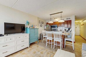 A compact kitchen with a dining area, a TV, and a blue cabinet.