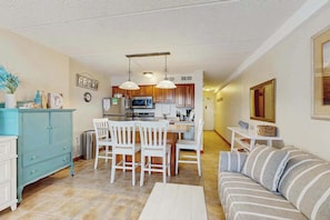 A compact living space with a kitchenette, dining area, and a sofa.