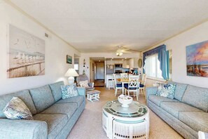 Ein Wohnzimmer mit zwei Sofas, einem Couchtisch und einem Essbereich mit Stühlen und einem Tisch.
