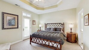 A bedroom with a bed, bedside tables, and a door. - Beautiful home in Bayside complex with pool, washer/dryer, & free WiFi (Ocean City)