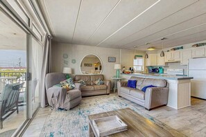 Ein modernes Wohnzimmer mit einer Couch, einem Couchtisch und einem Essbereich mit Küchenzeile.