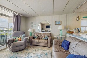 Ein Hotelzimmer mit einer Couch, einem Sessel und einem kleinen Tisch mit einer Lampe.