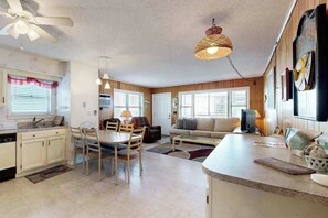 A compact kitchen with a dining area, a ceiling fan, pendant lights, and a large window. - The Bounty W1 (Ocean City)