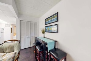 A room with a dining table, chairs, a sofa, and two framed artworks on the wall. - Beach House 202, ocean view & balcony (Ocean City)