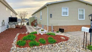 A residential area with two houses, a mailbox, and a landscaped garden with mulch and rocks. - Canal front home with free WiFi, deck, private dock, shared pool & tennis (Ocean City)