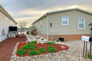 A residential area with two houses, a mailbox, and a landscaped garden with mulch and rocks. - Canal front home with free WiFi, deck, private dock, shared pool & tennis (Ocean City)
