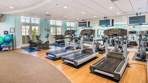 Een sportschool met loopbanden, fitnessballen en gewichten.