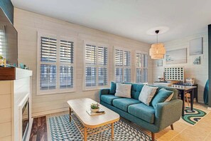 Ein modernes Wohnzimmer mit einer Couch, einem Couchtisch und einem Essbereich mit Tisch und Stühlen.