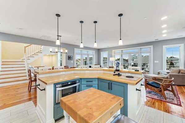 A modern kitchen with a central island, built-in appliances, and pendant lighting. - Canal-front getaway with private hot tub, large deck & firepit - dog-friendly (Ocean City)