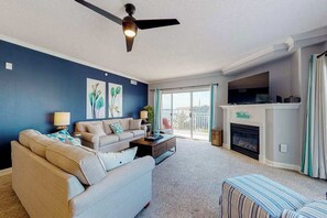 A living room with a sofa, coffee table, and fireplace. - Bahia Vista II 305 (Ocean City)