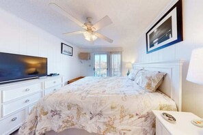 A bedroom with a bed, a television, a ceiling fan, a window, and a framed picture on the wall. - Waterfront Condo - Shared dock - Free WiFi, Partial AC, Washer/Dryer (Ocean City)