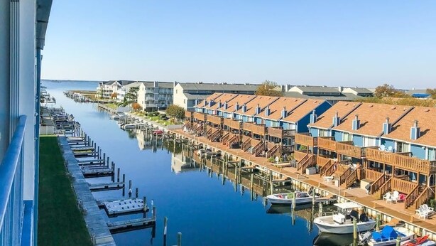 A waterfront hotel with row houses, docks, and boats. - Blue Marlin 402 (Ocean City)