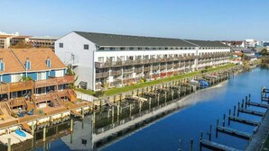 A waterfront hotel with multiple balconies, a dock, and a marina. - Blue Marlin 402 (Ocean City)