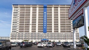 Un hotel de varios pisos con un llamativo letrero vertical azul que dice 'CAROUSEL'.