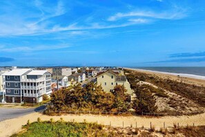 Eine Küstenwohngegend mit Häusern, einem Strand und blauem Himmel.