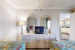 Ein Hotelzimmer mit Bett, Fernseher auf einem Schminktisch, Lampe und Spiegel.