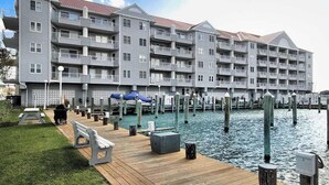 Een hotel met meerdere verdiepingen, balkons, een aanlegsteiger en uitzicht op het water.