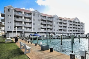 A multi-story hotel with balconies, a dock, and a waterfront view. - Charming bayfront condo in Old Town with balcony, WiFi, AC, & shared pool (Ocean City)