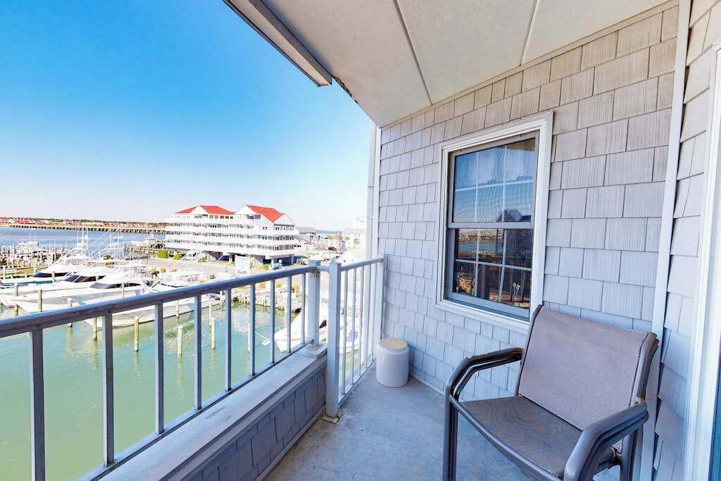 Un balcon donnant sur une marina et un immeuble aux toits rouges.