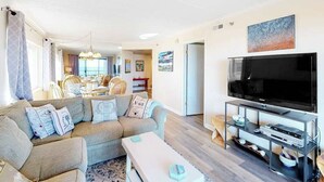 A living room with a sofa, TV, and entertainment unit. - Waikiki 102 (Ocean City)