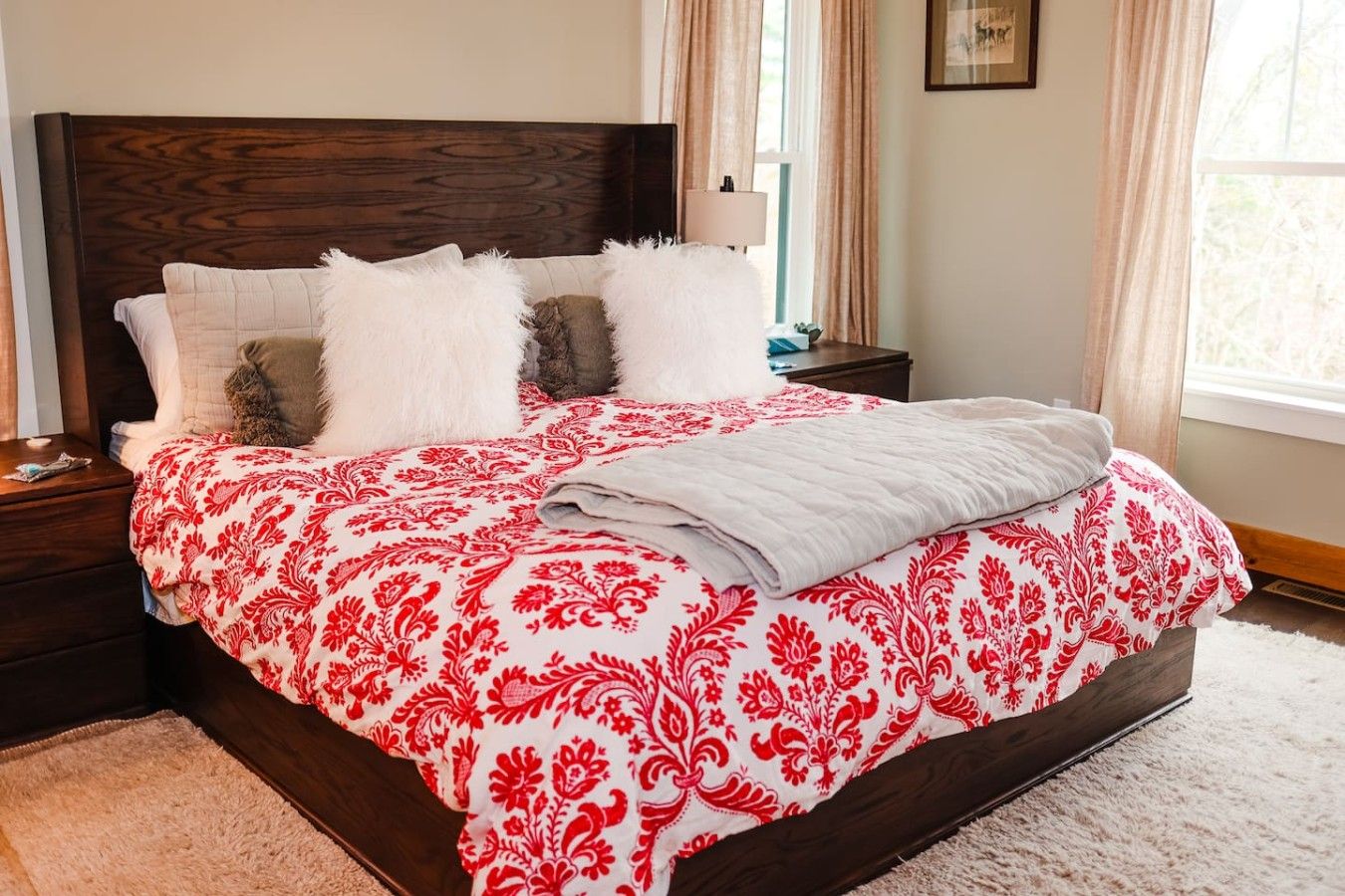 A bed with a patterned bedspread, a wooden headboard, and a bedside table with a lamp.
