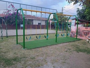 A playground with swings and a climbing structure.