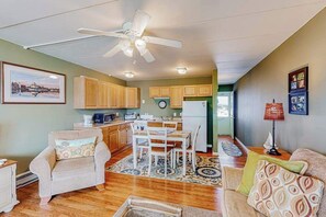 A spacious living area with a dining table, chairs, a sofa, and a ceiling fan. - Bay Colony 36 (Ocean City)