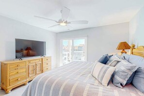 A bedroom with a bed, a TV on a wooden dresser, a ceiling fan, and a window with a view. - Baywatch III 304D (Ocean City)