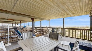 A covered outdoor area with a table and chairs, a hammock, and a view of the beach. - Oceanfront escape close to boardwalk with balcony, W/D, and direct beach access (Ocean City)