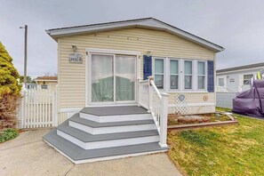 A single-story mobile home with a front porch, a mailbox, and a small garden area. - Assateague Pointe - 12401 Windlass Way (Berlin)