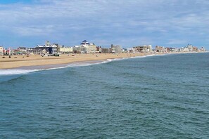 Eine Küstenstadt mit Strand, Gebäuden und blauem Himmel.