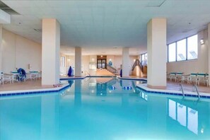 An indoor swimming pool with clear water, surrounded by white walls and columns, with a staircase leading to an upper level. - Marigot Beach 1207 (Ocean City)