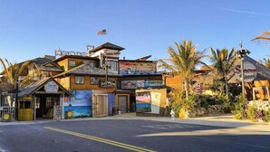 A multi-story building with a beach-themed mural, a flag, and a sign for 'Seacrest.' - Al-Be Vacation Villas, Unit 1 (Ocean City)