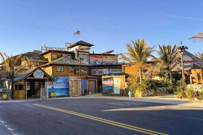 A multi-story building with a beach-themed mural, a flag, and a sign for 'Seacrest.' - Sunny condo 2 blocks from beach with fast WiFi & W/D - dog-friendly (Ocean City)