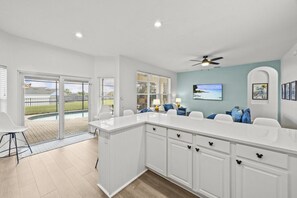 A modern kitchen with a large island, sliding glass doors to a patio, and a ceiling fan. - Six bedroom  in United States of America, Kissimmee (Kissimmee)