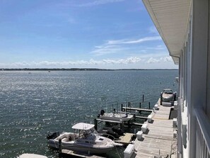 A marina with boats docked, a wooden dock, and a clear view of the water. - Renovated bayfront condo with water-view balcony & fast WiFi - walk to beach (Ocean City)