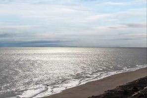 Uma praia com vista clara do oceano e uma costa distante.