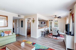 A modern living room with a sofa, coffee table, and a dining area with chairs and a table. - Fantastic waterfront escape with furnished deck, WiFi, shared pool & central AC (Ocean City)