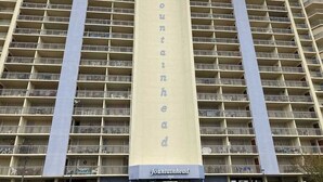 A high-rise building with a prominent vertical sign reading 'fountainhead.' - Fountainhead Towers 305 (Ocean City)