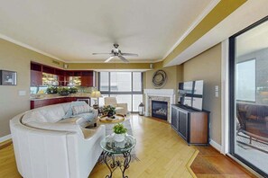 A living room with a sofa, a coffee table, and a fireplace. - Luxurious Ocean Front Condo w/Beach Access, Central AC & Gas Fireplace (Ocean City)