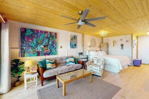 Ein gemütliches Zimmer mit einem Bett, einem Sofa, einem Couchtisch und einem Deckenventilator.