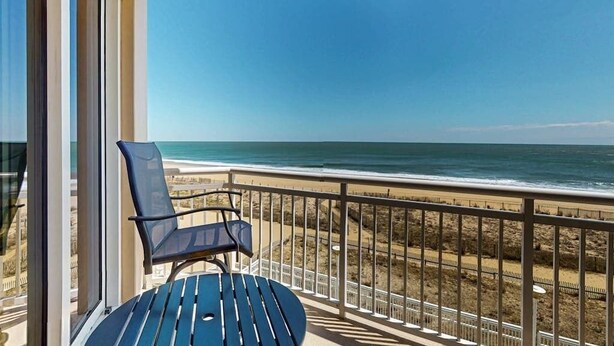 Een balkon met uitzicht op het strand en de oceaan.