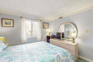 A bedroom with a bed, a dresser, a television, and a large mirror. - 1st floor condo w/screened porch kitchen, WiFi Central AC & shared pool (Ocean City)