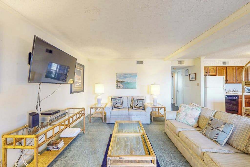 A living room with a sofa, coffee table, TV, and lamp.